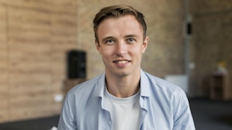 a man in a blue shirt smiles at the camera