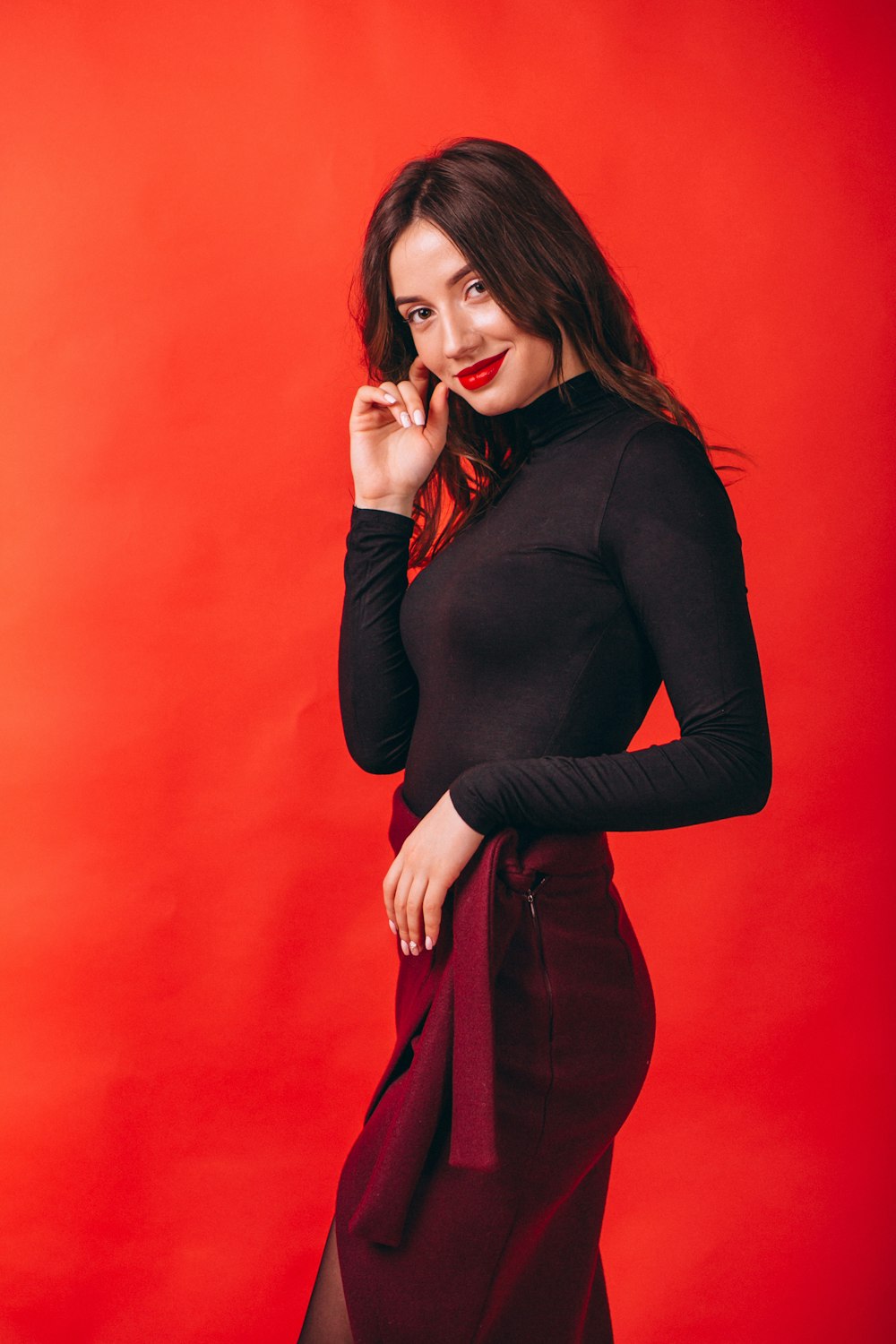 a woman posing for a picture in a red background