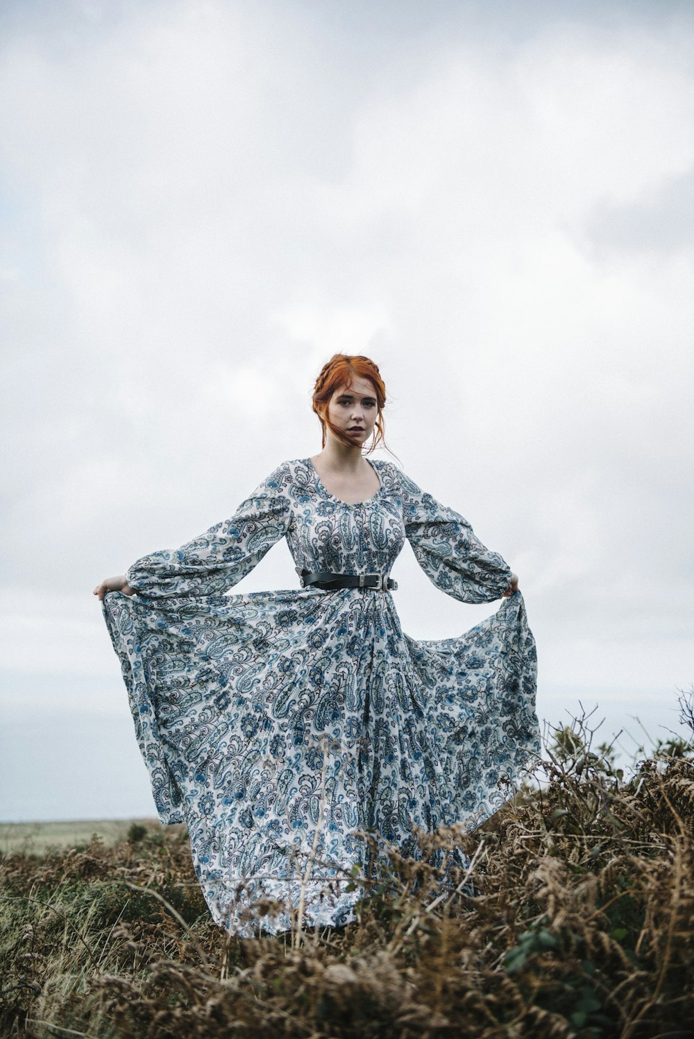 a woman in a dress standing in a field