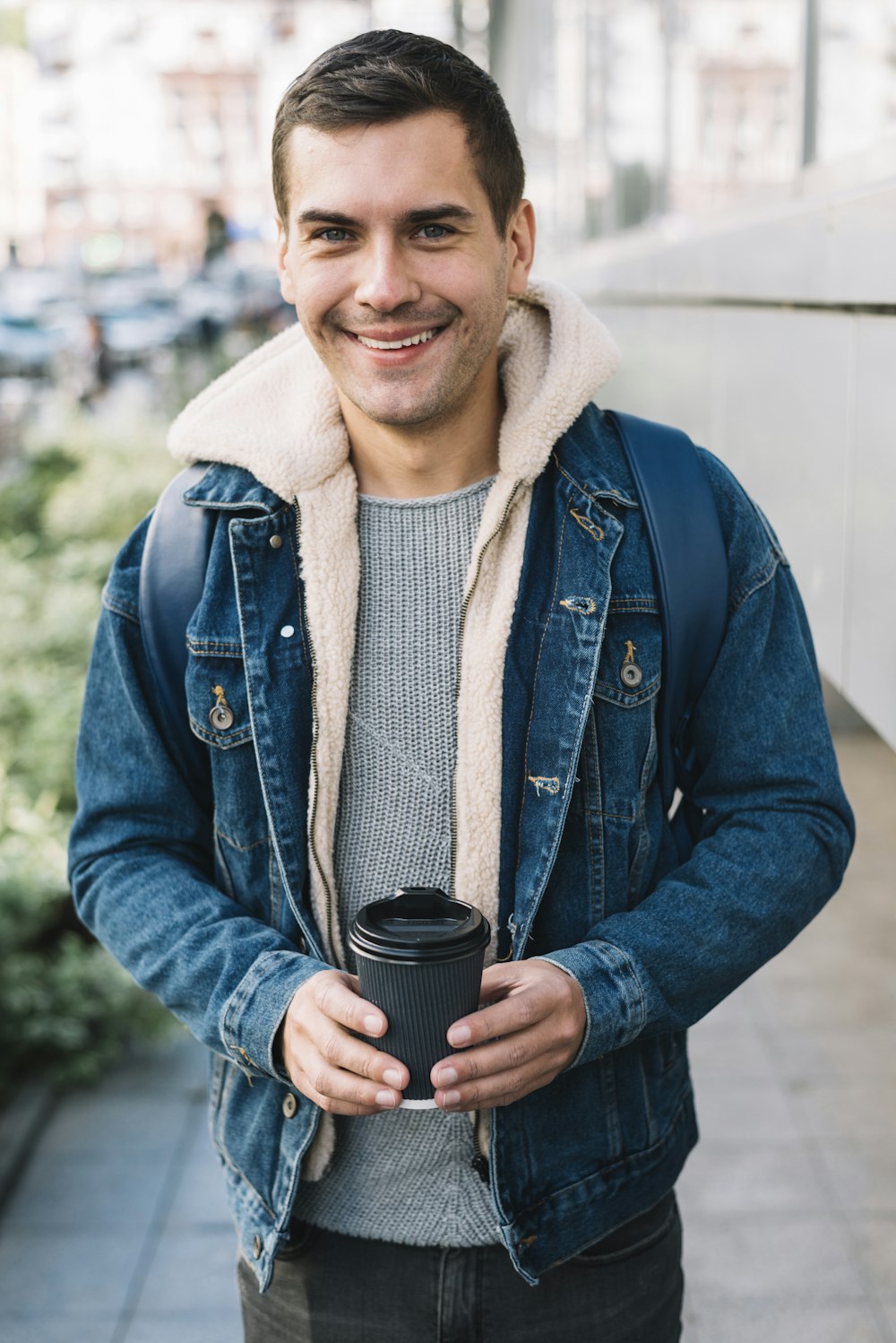 Ein Mann, der eine Tasse Kaffee hält und lächelt