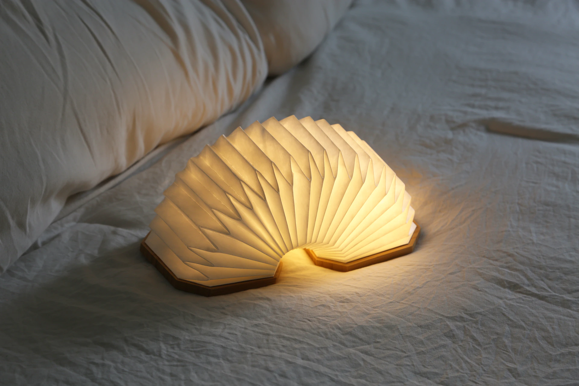 a white lamp sitting on top of a bed