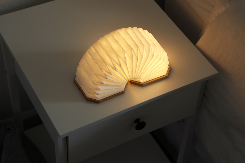 a book shaped lamp sitting on top of a white table