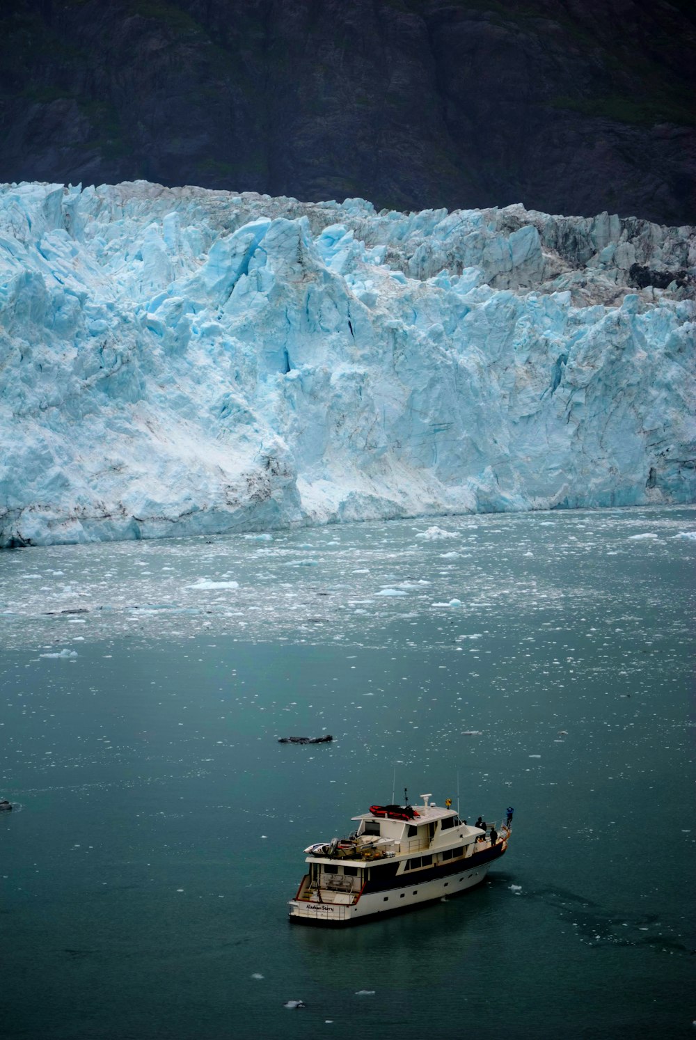 a boat in the water near a large glacier