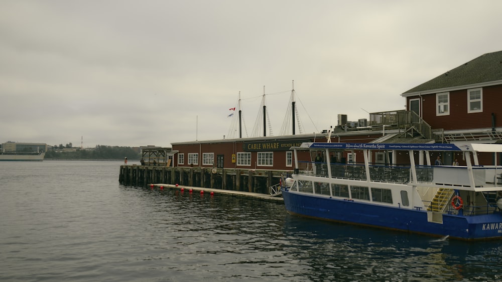 a blue and white boat docked at a dock