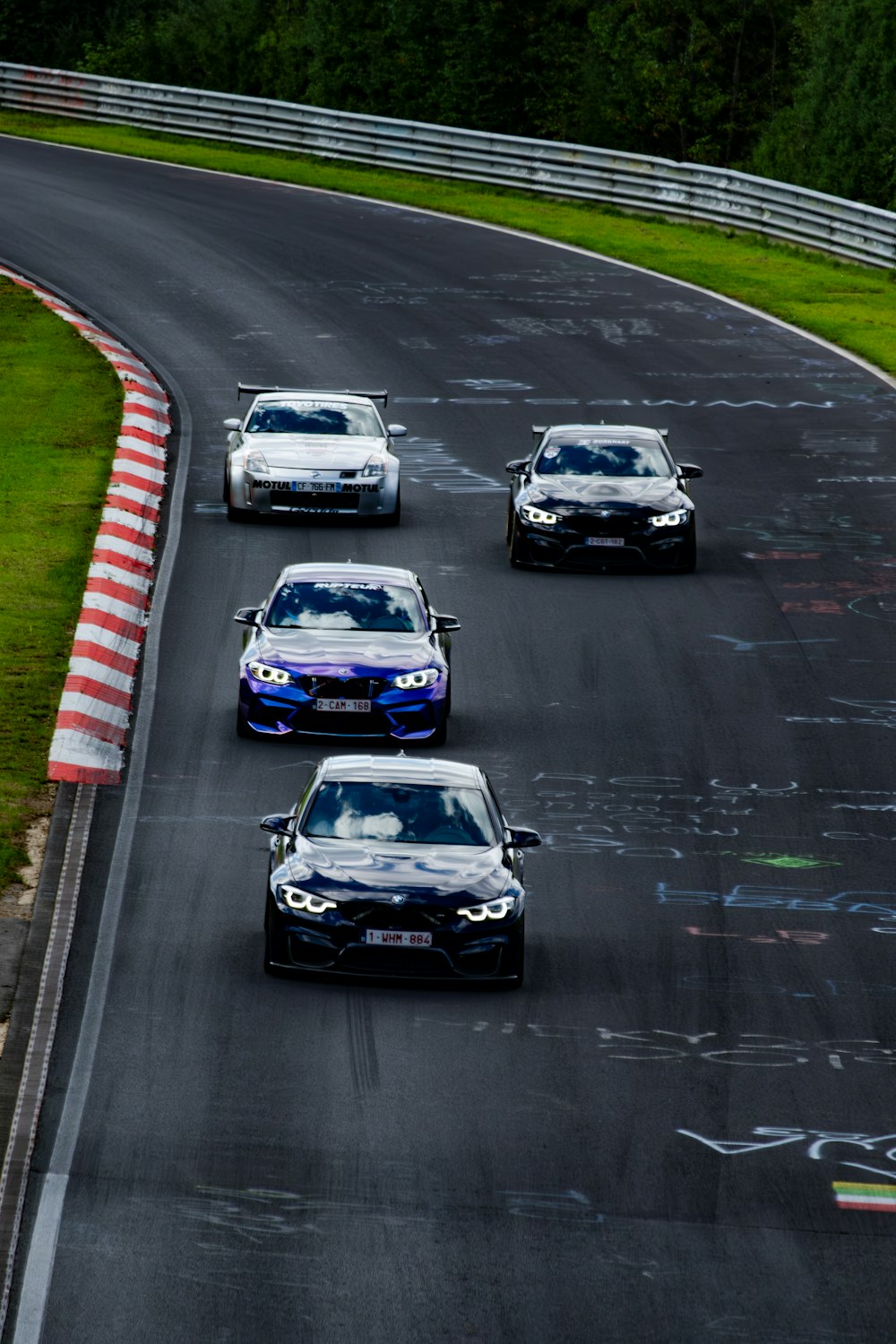 a group of cars driving down a race track