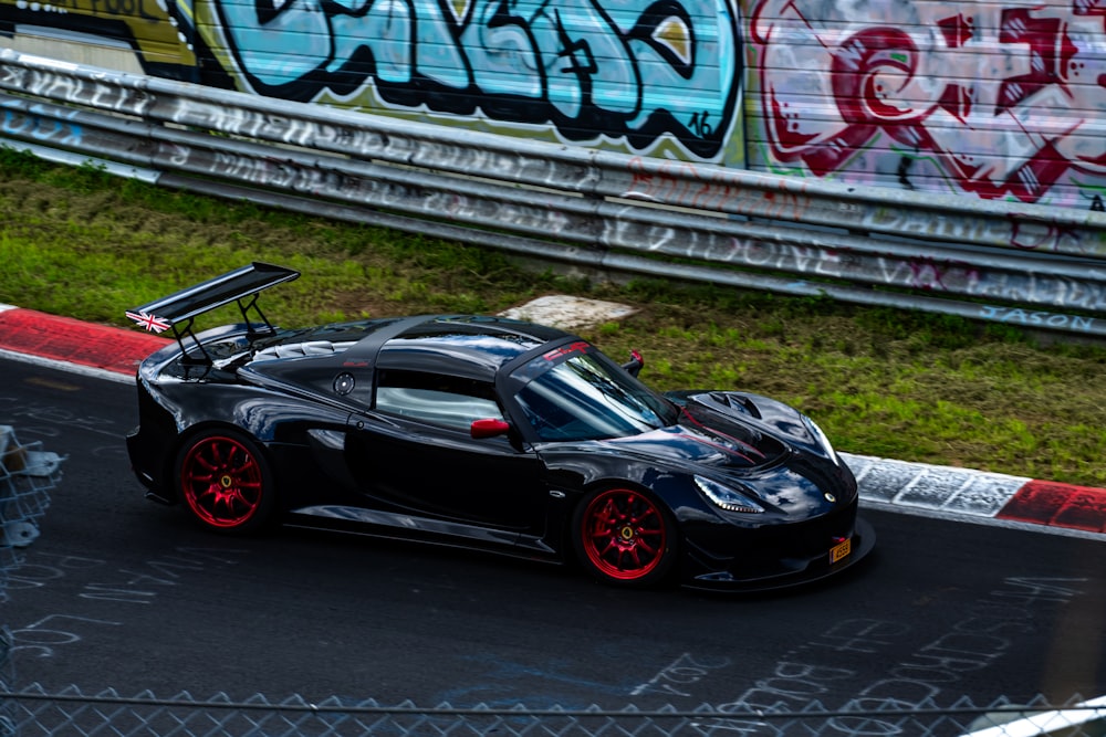 a black sports car driving down a race track