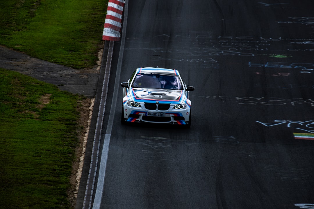 a white car driving down a race track,