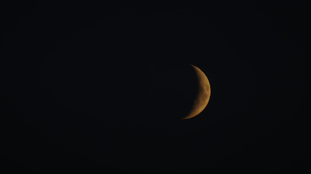 a half moon is seen in the dark sky