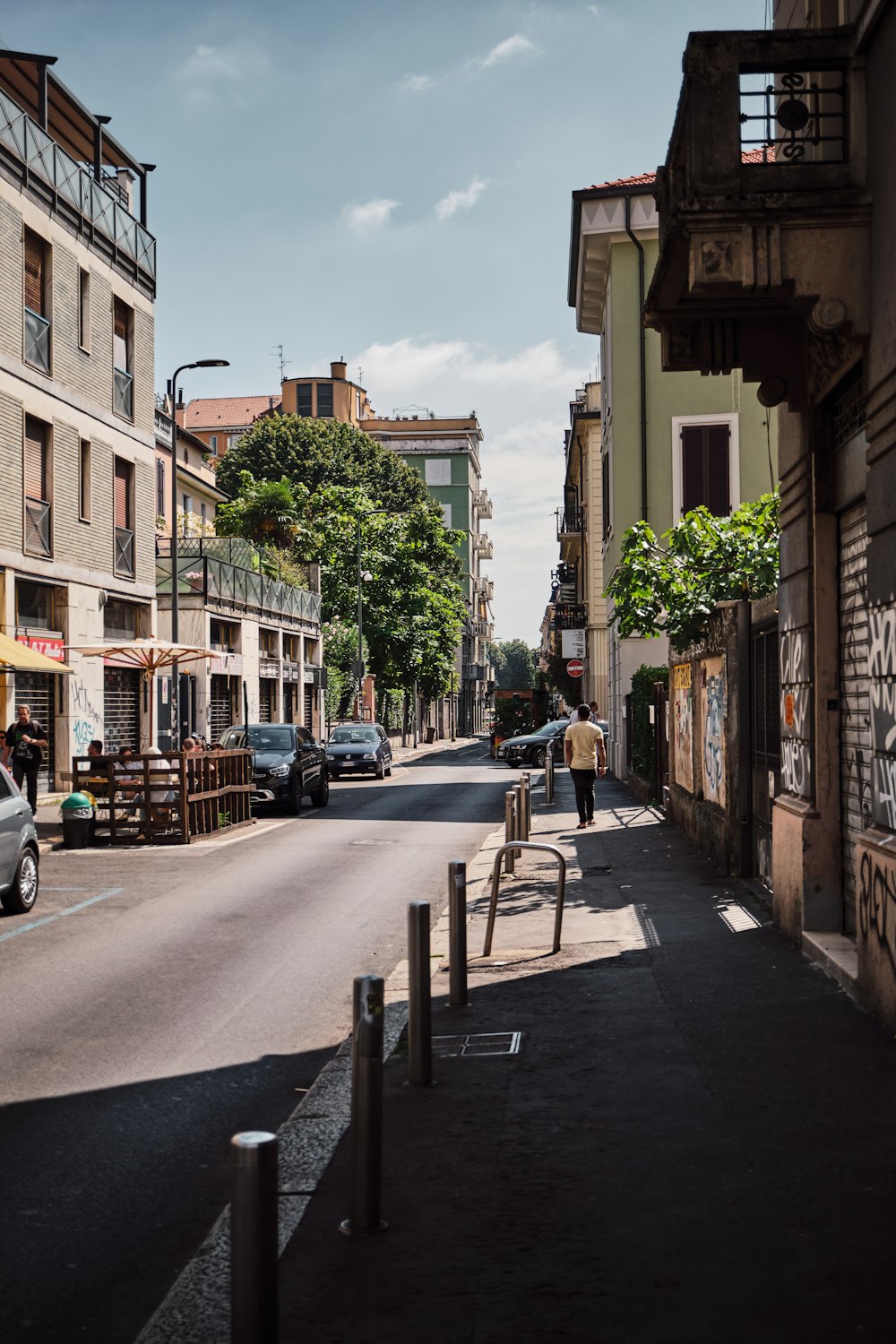 uma pessoa andando por uma rua ao lado de edifícios altos