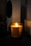A cozy living room with a lit soy wax scented candle on a wooden table.