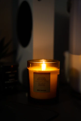 Cozy candles with custom labels glowing softly in warm light