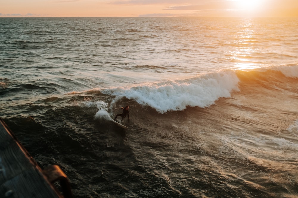 海の波に乗ってサーフボードに乗る人