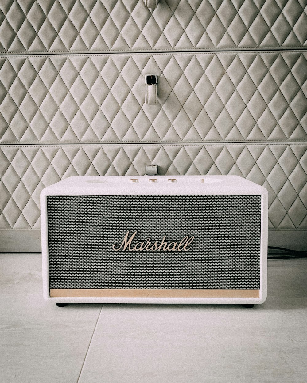 a bluetooth speaker sitting on top of a tiled floor