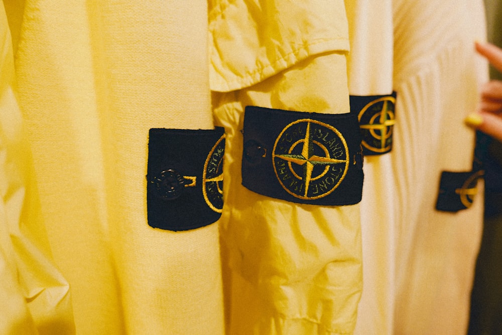a yellow shirt with a compass patch on it