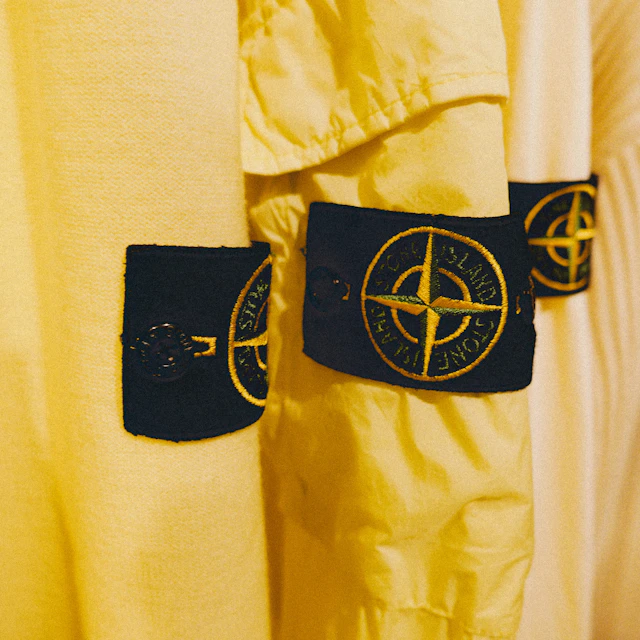 A yellow garment with a compass patch sewn on it