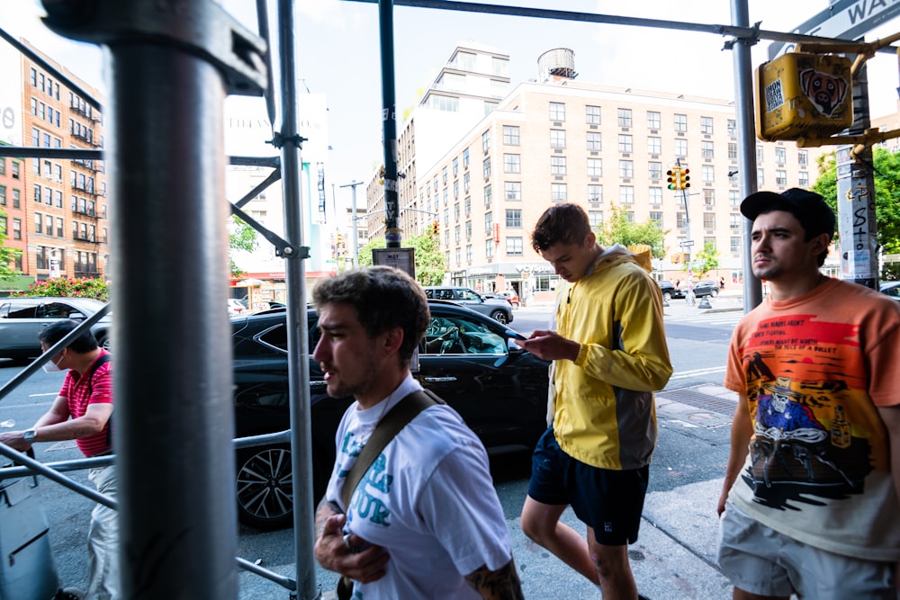 a group of men walking down a street next to a traffic light