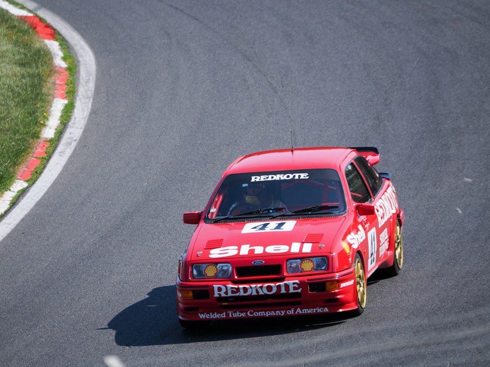 a red car driving down a race track