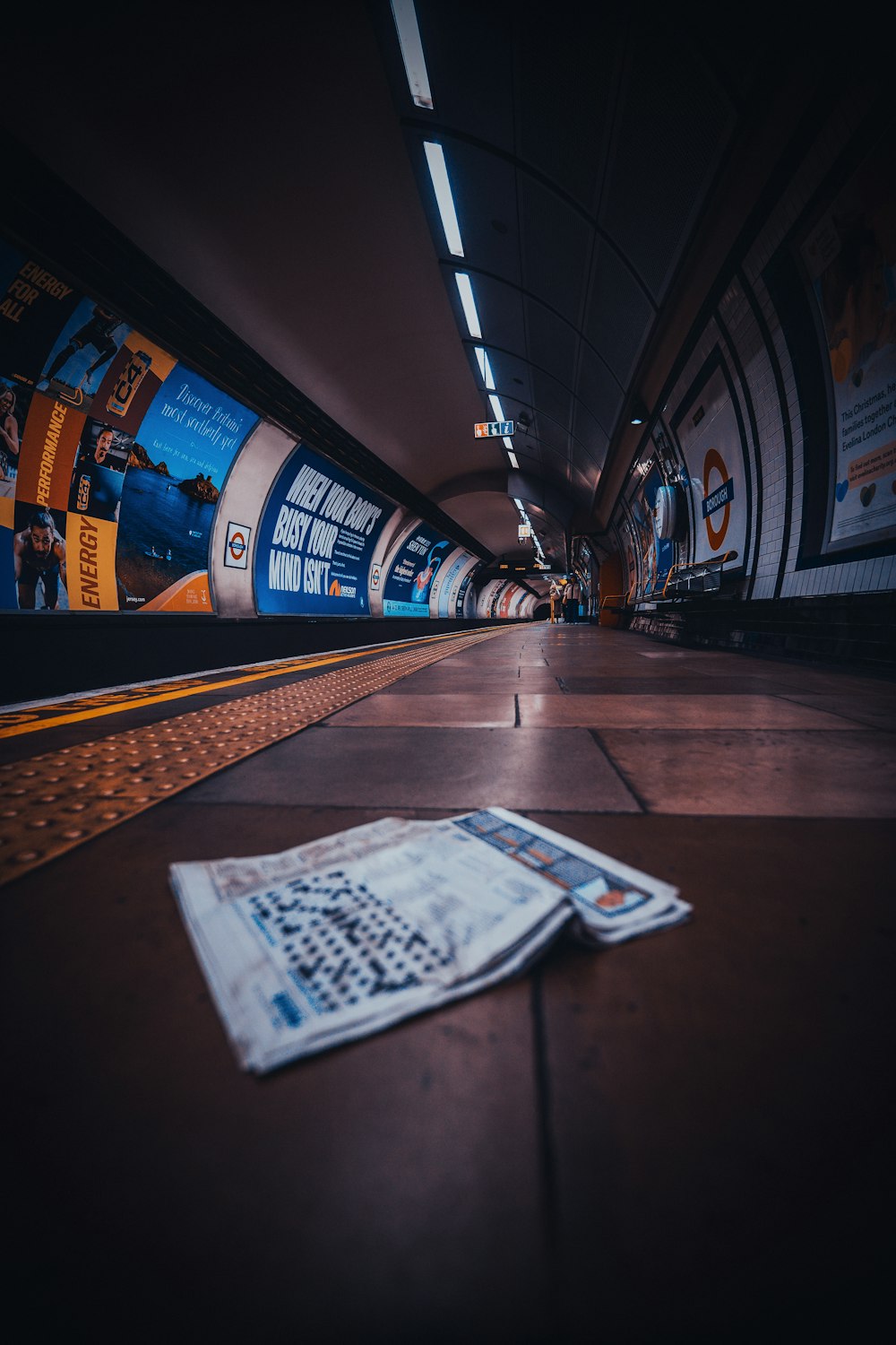 a newspaper laying on the ground in a subway station