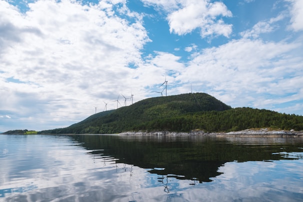A serene landscape featuring wind turbines on a hillside.