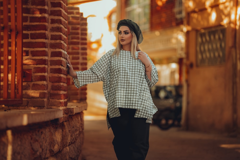 a woman is walking down the street with a hat on