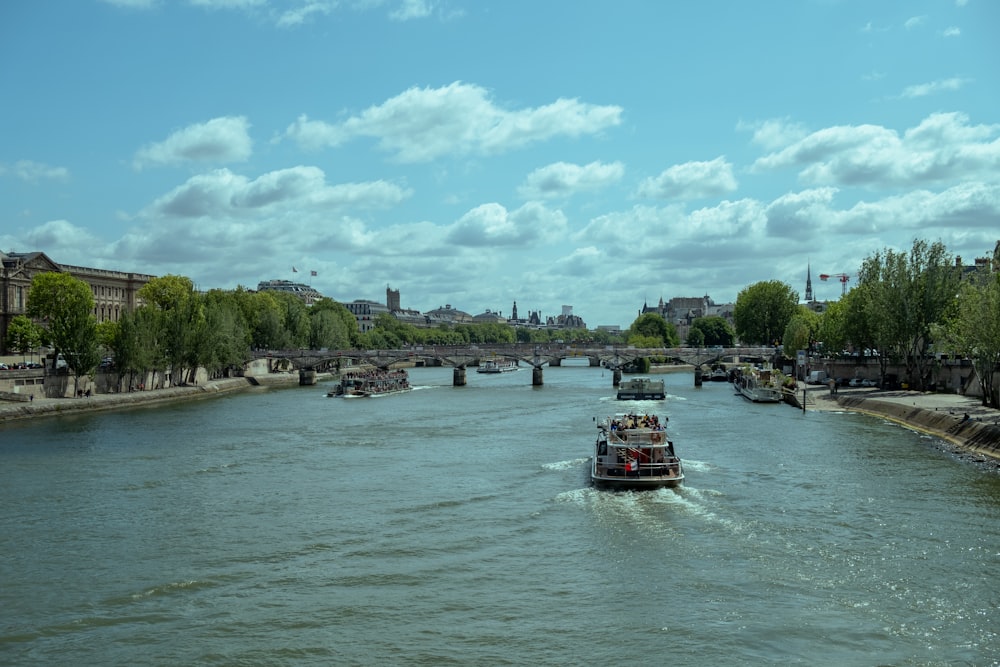 a boat traveling down a river next to a bridge