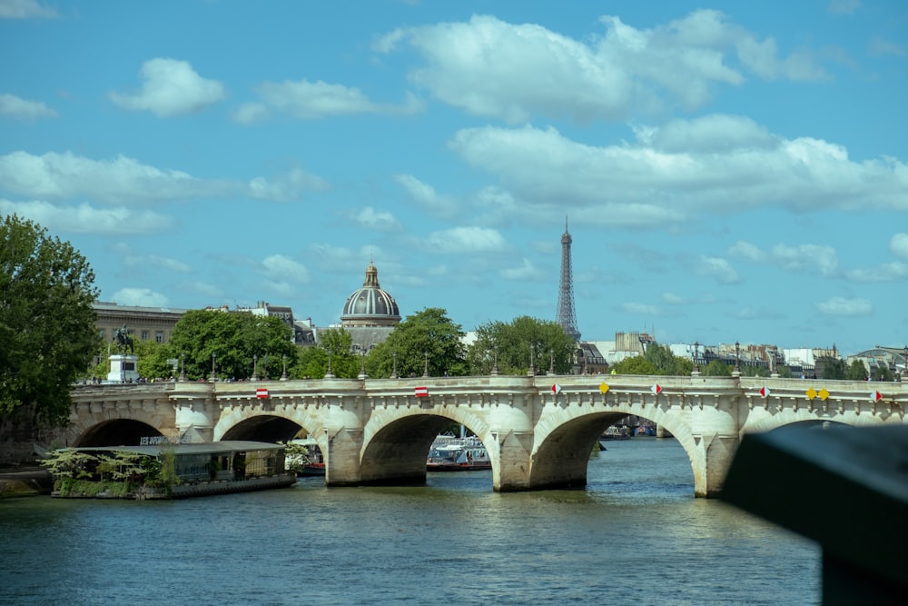 a bridge over a body of water with a tower in the background