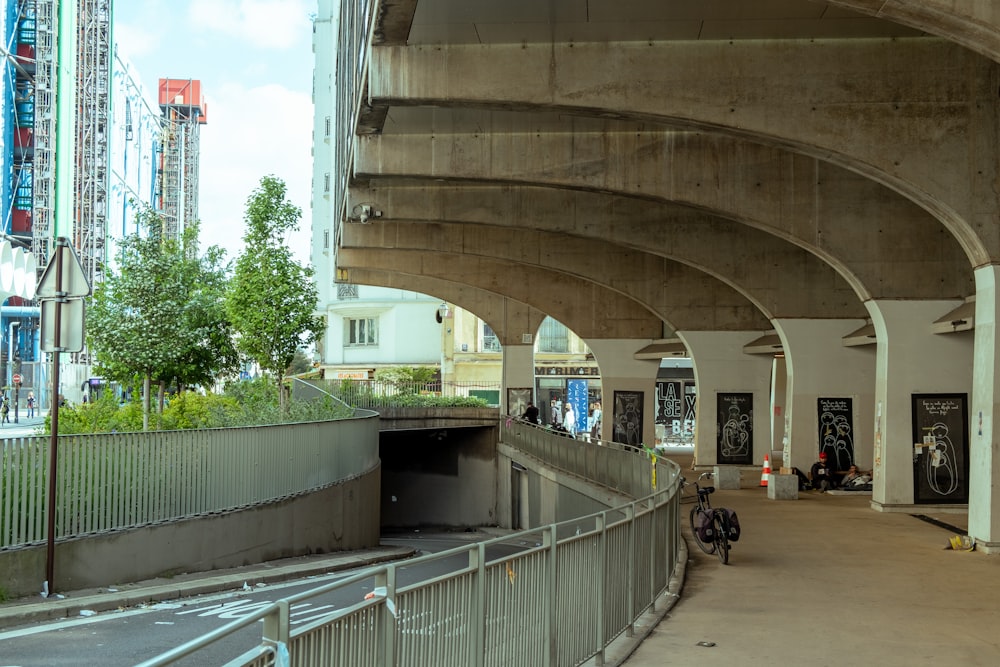 a walkway under a bridge in a city