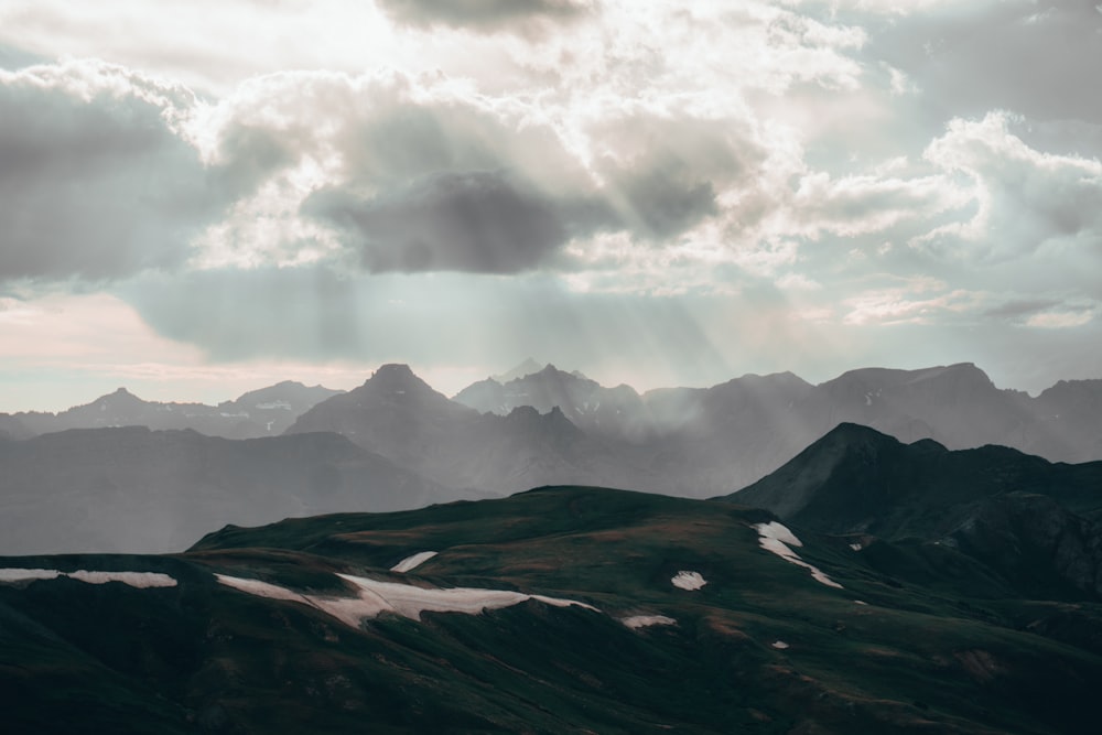 the sun shines through the clouds over the mountains