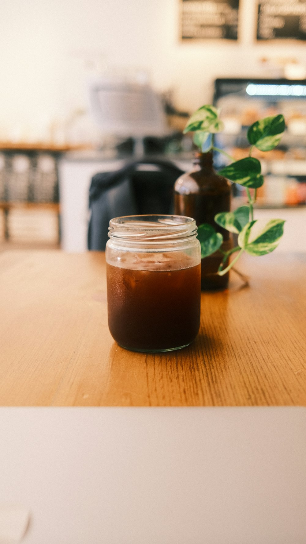 a jar of liquid sitting on top of a wooden table