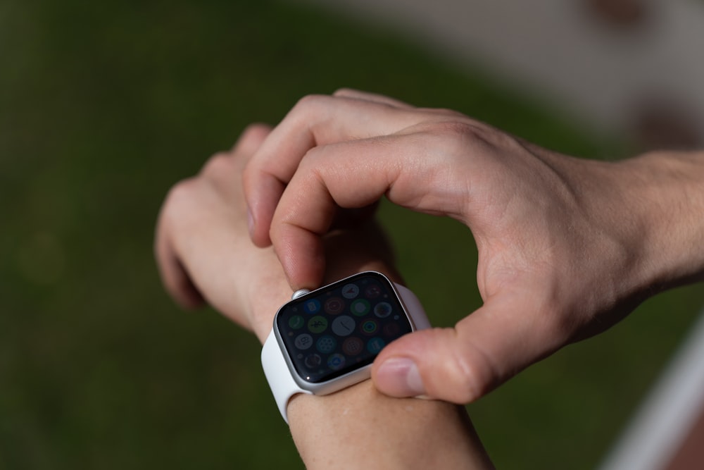 a person holding a smart watch in their hand