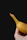 Close-up of a hand holding a crispy banana chip with a rustic background