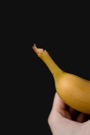 Hands holding a perfectly peeled banana ready to eat.
