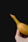 Close-up of a hand holding a crispy banana chip with a rustic background