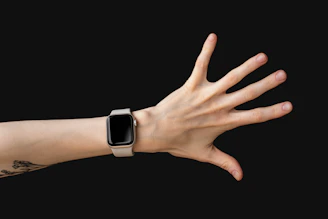 Close-up of a sleek smart ring glowing softly on a wrist against a minimalist white background.