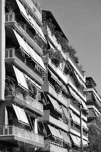 a tall building with balconies and plants on the balconies