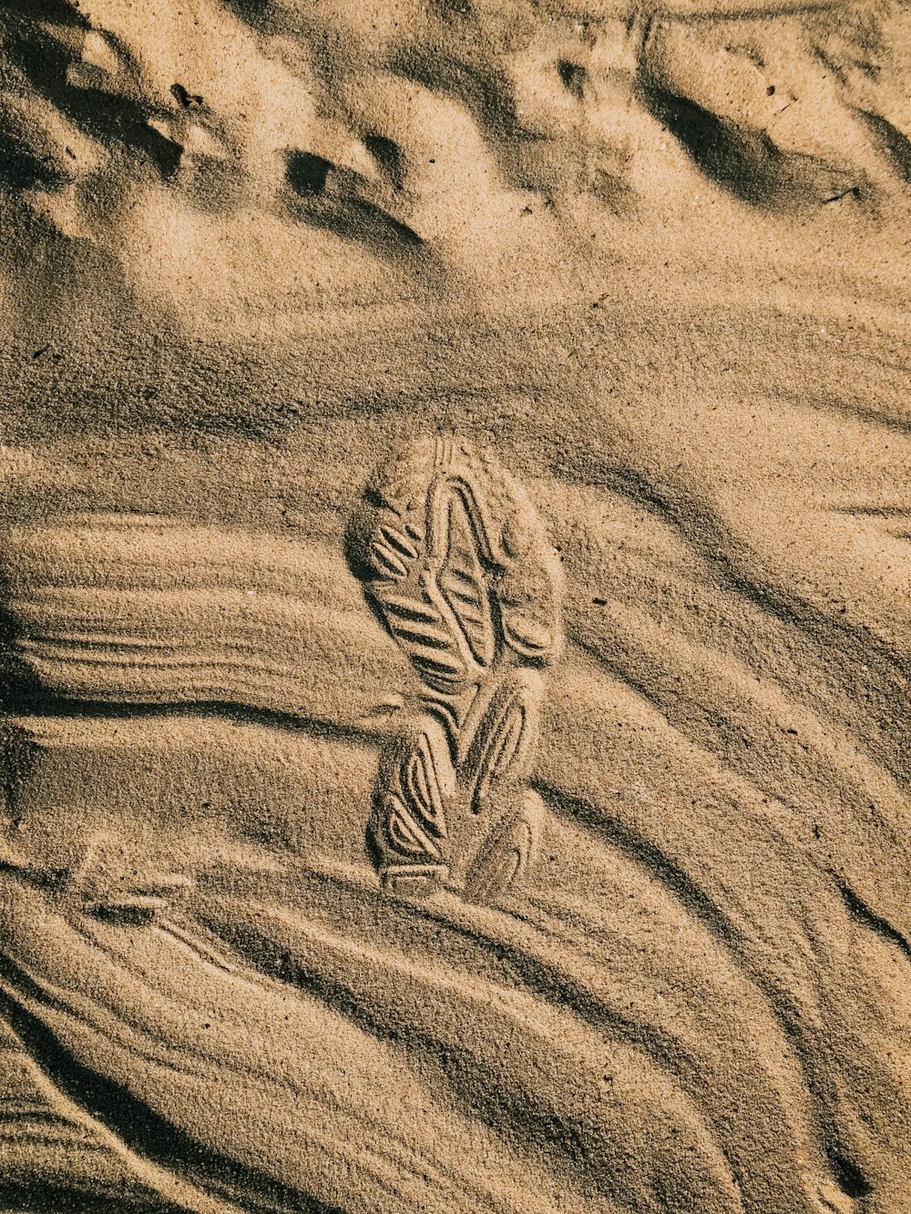 a person's footprints in the sand on a beach