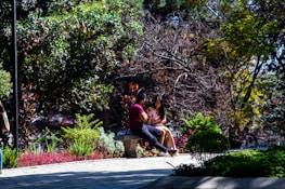 A happy couple enjoying a sunny day at a picturesque park.