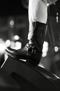 A close-up of elegant women's leather boots with intricate stitching and a soft suede finish.