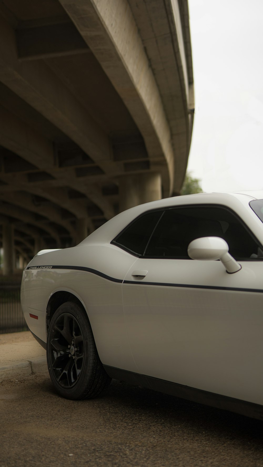 a white car parked in front of a bridge