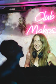 DJs smiling and chatting live on air with headphones in a modern radio booth