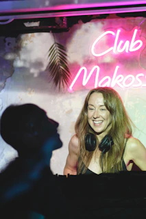 DJs smiling and chatting live on air with headphones in a modern radio booth