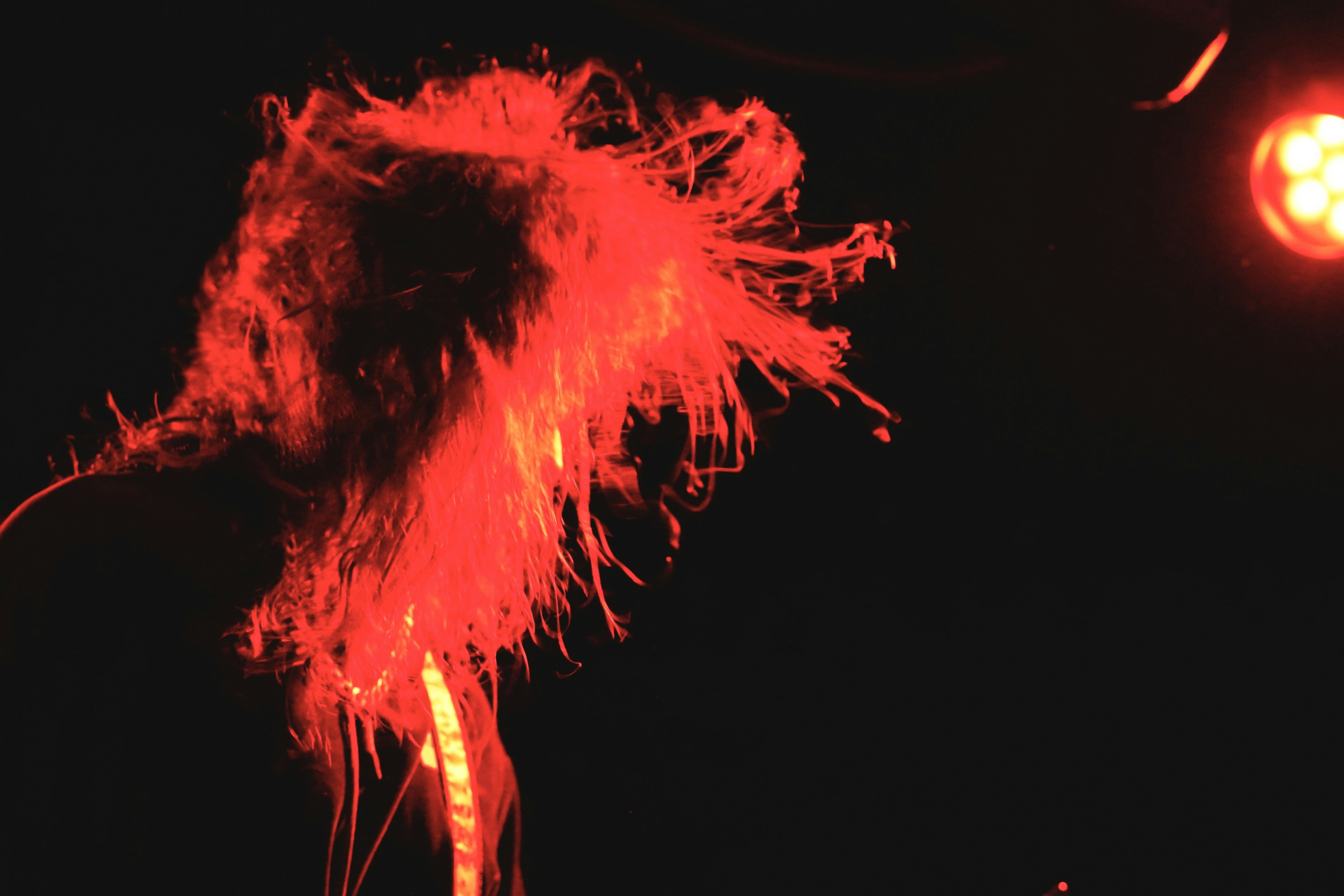 uma pessoa com cabelos compridos em pé em frente a um poste de iluminação pública
