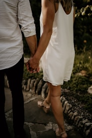 a man and a woman holding hands and walking