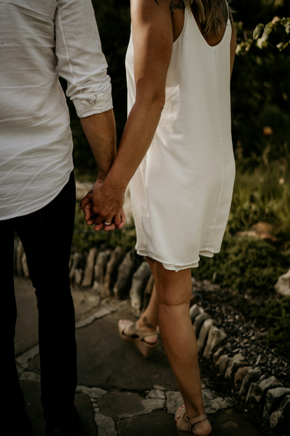 a man and a woman holding hands and walking