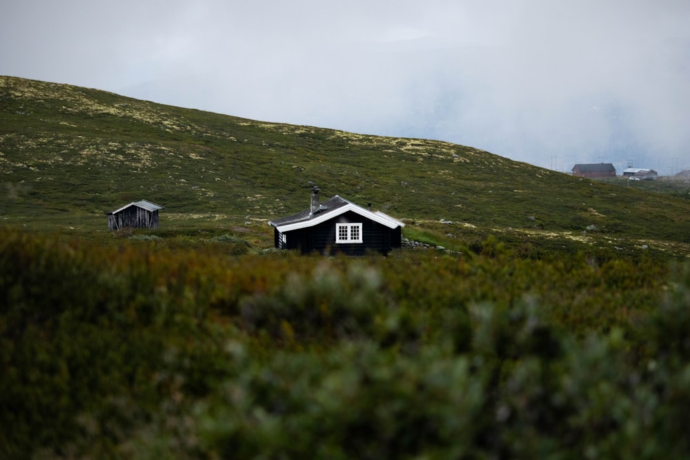 Una piccola casa seduta sulla cima di una collina verde lussureggiante