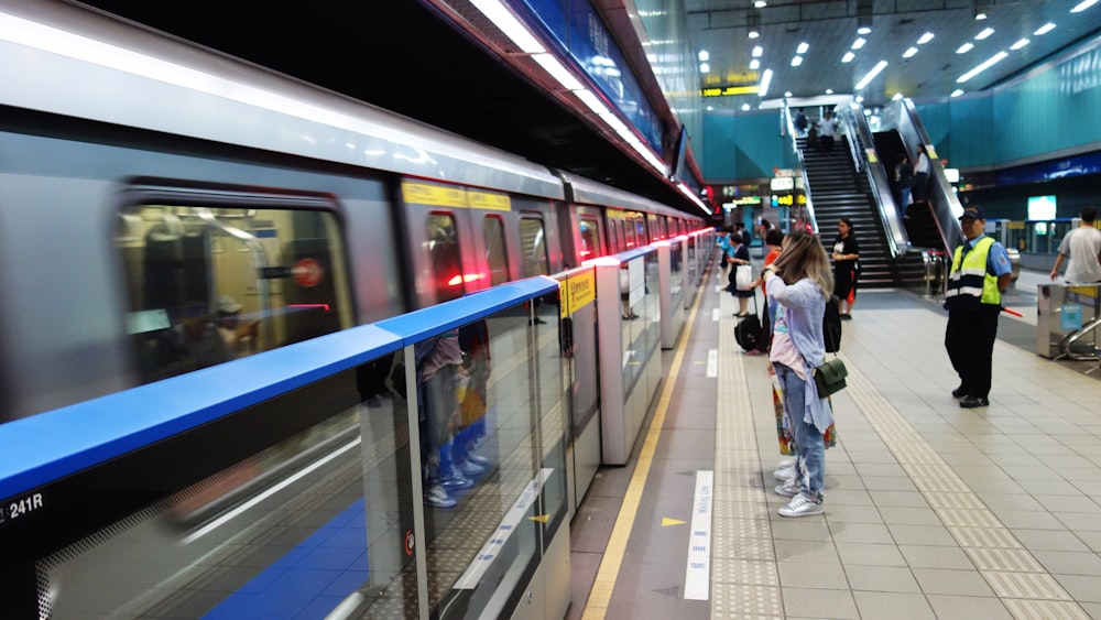 a woman standing next to a train at a train station