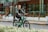 A happy customer riding an electric bike in an urban setting.