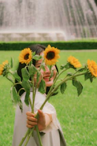 A happy client interacting with a florévo flower stand at a sunny celebration.