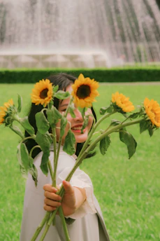 A happy client interacting with a florévo flower stand at a sunny celebration.