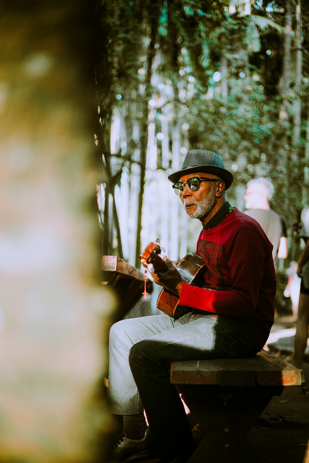 a man sitting on a bench playing a guitar